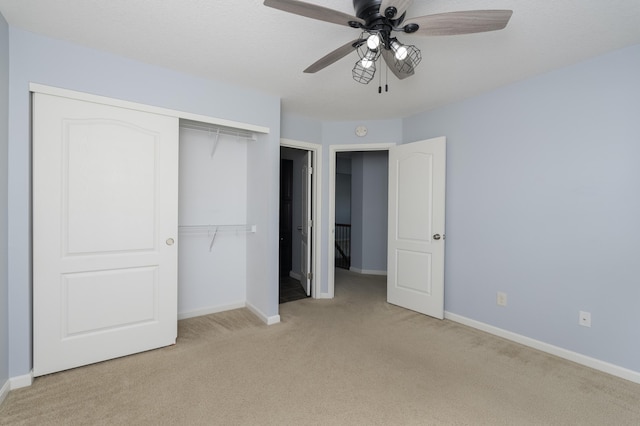 unfurnished bedroom with a closet, baseboards, a ceiling fan, and carpet flooring