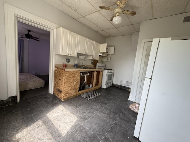 2749 Alexandria Ave, Covington, KY 41015 - kitchen featuring a paneled ceiling, ceiling fan, white cabinets, and white appliances