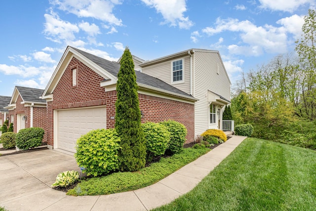 view of side of home featuring a garage, a yard, concrete driveway, and brick siding