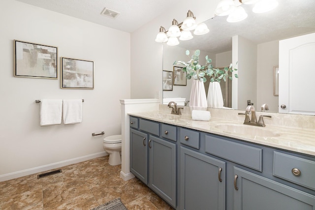 bathroom with toilet, baseboards, visible vents, and a sink