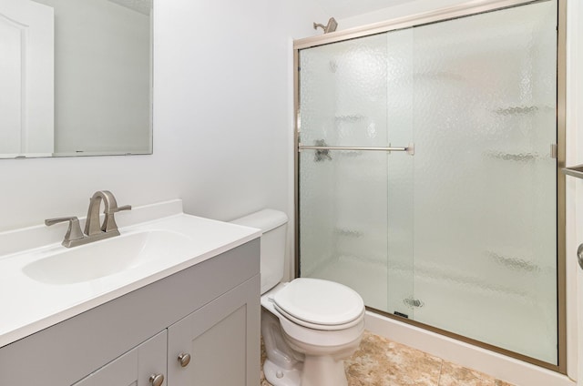 bathroom with vanity, a shower stall, and toilet