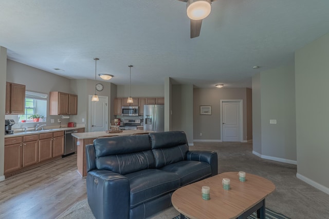 living area featuring baseboards and ceiling fan