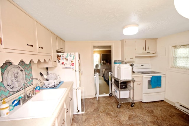 kitchen with white appliances, light countertops, a textured ceiling, under cabinet range hood, and a sink
