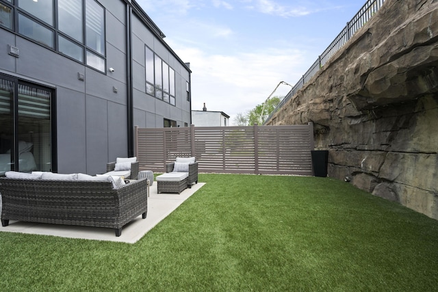 view of yard with fence, a patio area, and outdoor lounge area