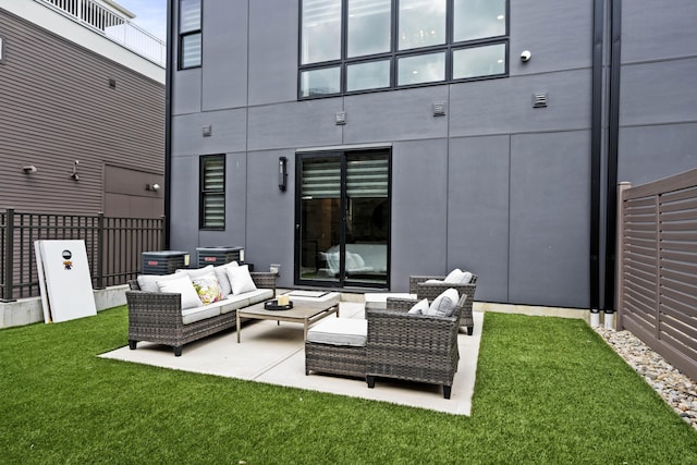 rear view of property featuring a yard, a patio, fence, and an outdoor hangout area