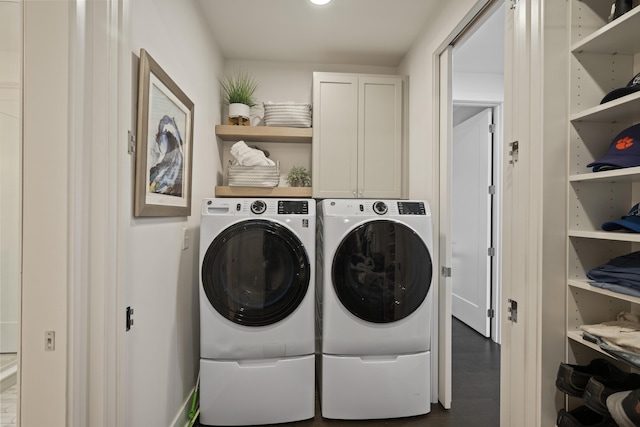 laundry area featuring cabinet space, wood finished floors, and washer and dryer