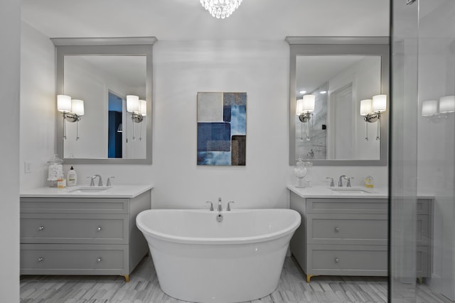 full bathroom with a sink, a freestanding tub, two vanities, and a stall shower