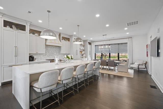 kitchen with light countertops, a large island, and visible vents