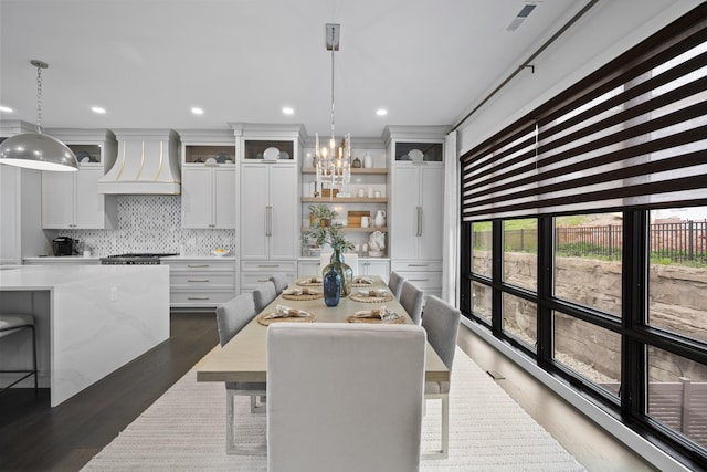 kitchen with a kitchen island, backsplash, light countertops, custom exhaust hood, and dark wood-type flooring