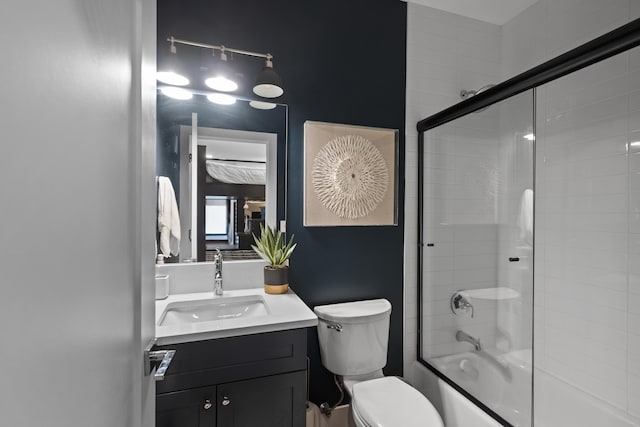 full bathroom featuring vanity, shower / bath combination with glass door, and toilet