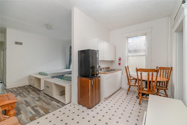 910 Hamlet St, Newport, KY 41071 - kitchen with visible vents, baseboards, freestanding refrigerator, light floors, and white cabinetry