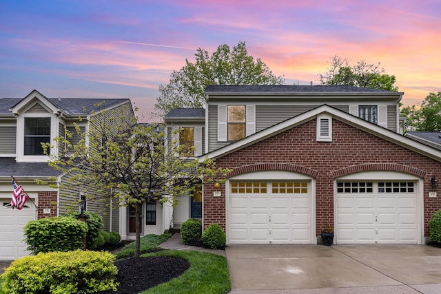 view of front facade featuring an attached garage, concrete driveway, and brick siding