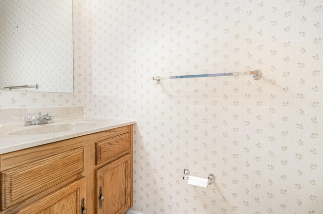 bathroom featuring vanity and wallpapered walls