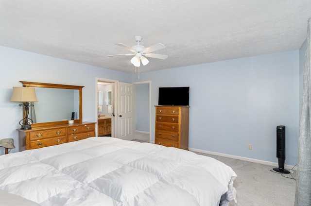 bedroom featuring baseboards, ensuite bathroom, carpet, and a ceiling fan