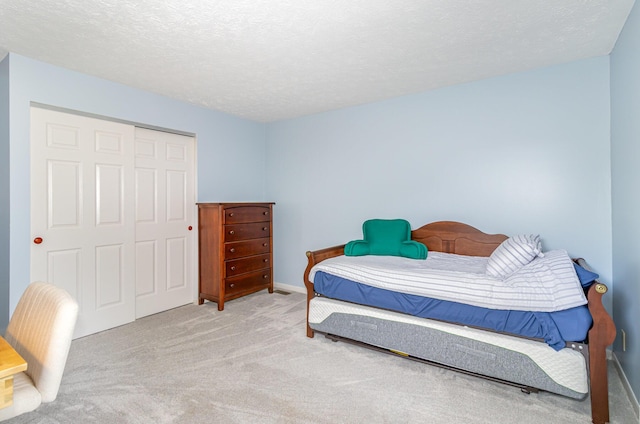 bedroom with baseboards, carpet, and a closet