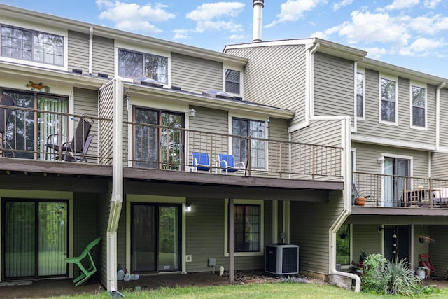 rear view of property with central AC and a balcony