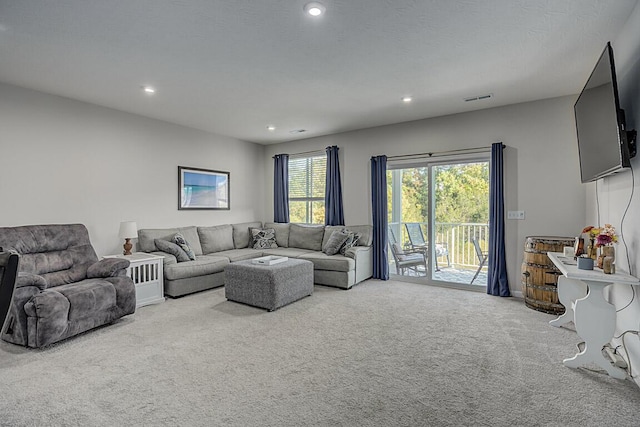 living area featuring carpet flooring, recessed lighting, and visible vents