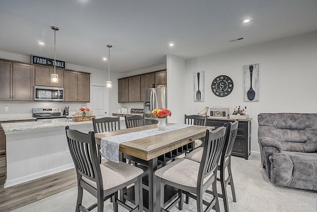 dining room with baseboards, light wood-type flooring, recessed lighting, and visible vents