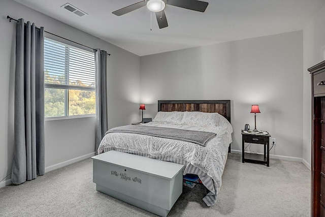bedroom featuring visible vents, baseboards, ceiling fan, and light carpet