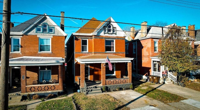 view of front of home with brick siding and covered porch