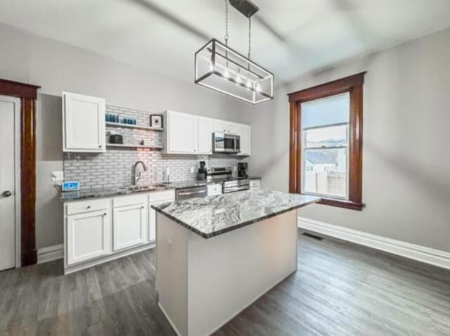 kitchen featuring white cabinets, stainless steel appliances, baseboards, and dark wood-style floors