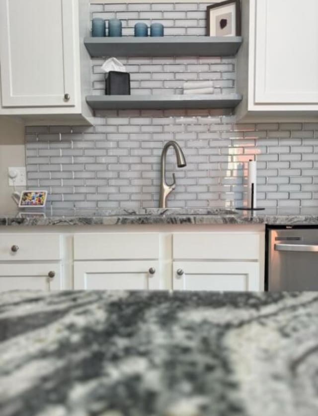kitchen featuring open shelves, white cabinetry, dishwasher, and tasteful backsplash