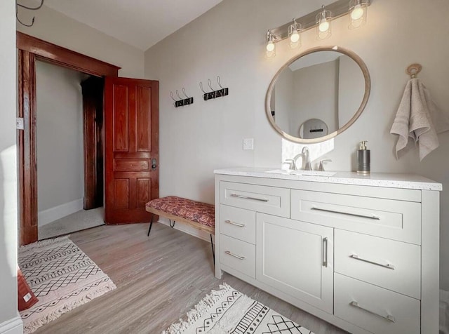 bathroom featuring vanity, baseboards, and wood finished floors