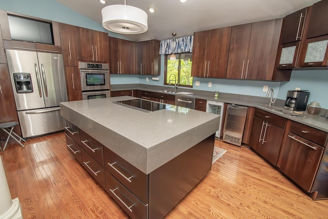kitchen with wine cooler, stainless steel appliances, light wood-type flooring, and a sink