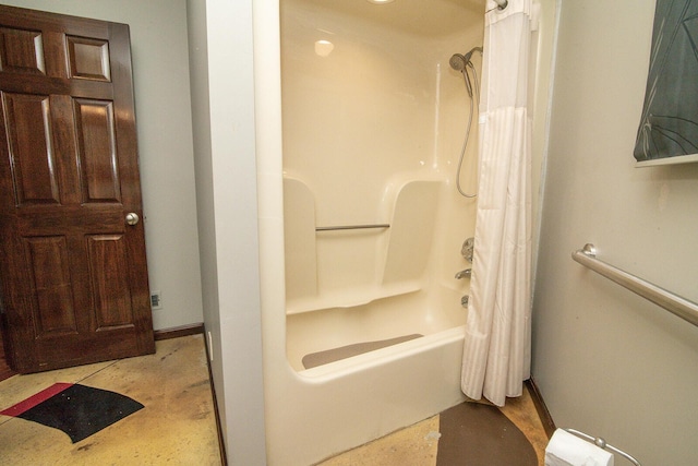 bathroom featuring baseboards and shower / tub combo