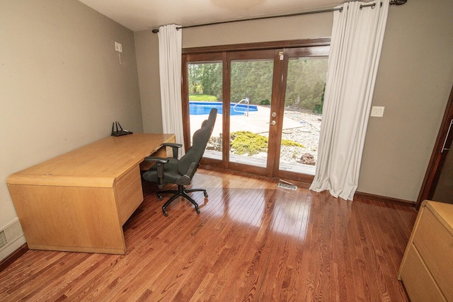 office space with light wood-type flooring, visible vents, and french doors