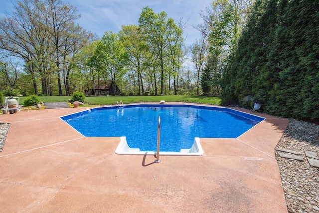 pool featuring a lawn and a patio area