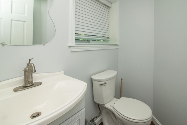 half bath featuring vanity and toilet