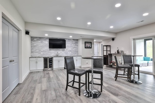 bar featuring recessed lighting, wet bar, light wood-style floors, and wine cooler