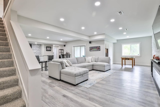 living area with light wood-style flooring, recessed lighting, baseboards, visible vents, and stairway
