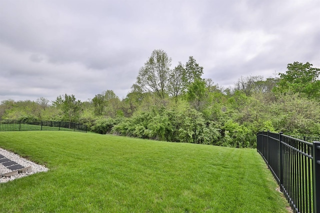 view of yard featuring fence and a forest view