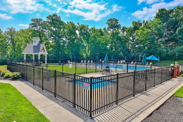 pool featuring fence, a gazebo, and a yard