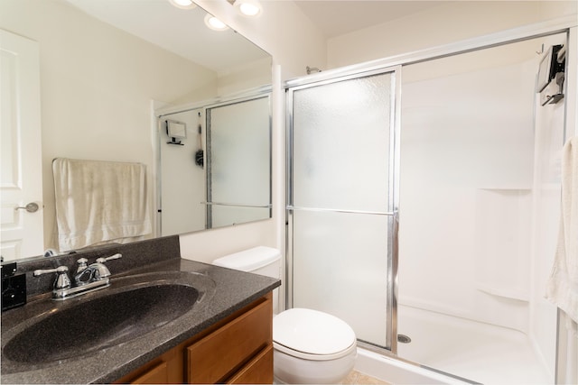 full bathroom with a stall shower, vanity, and toilet