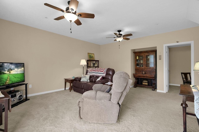 living area with baseboards, a ceiling fan, and light carpet