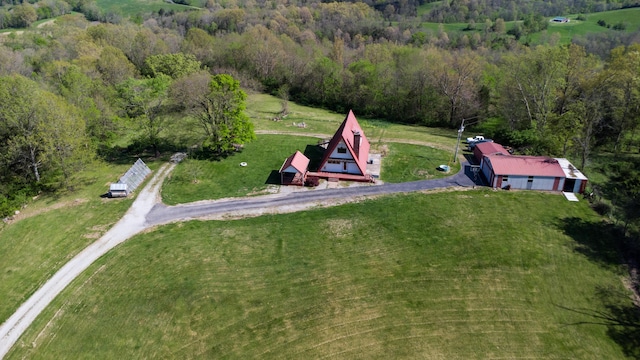 aerial view of property and surrounding area with a heavily wooded area
