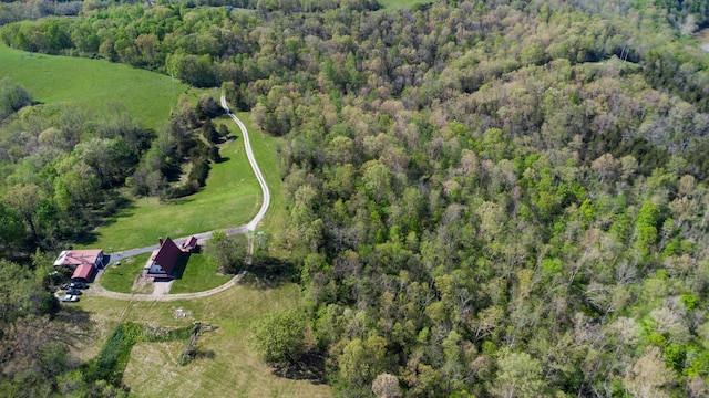 aerial view of property and surrounding area featuring a heavily wooded area