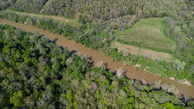 aerial view of property and surrounding area with a large body of water and a heavily wooded area
