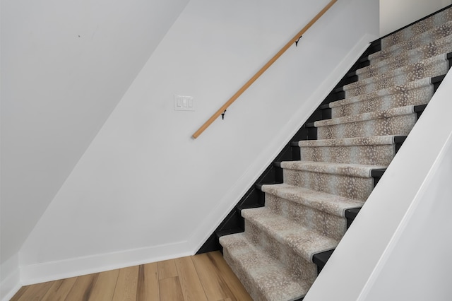 staircase with wood finished floors and baseboards