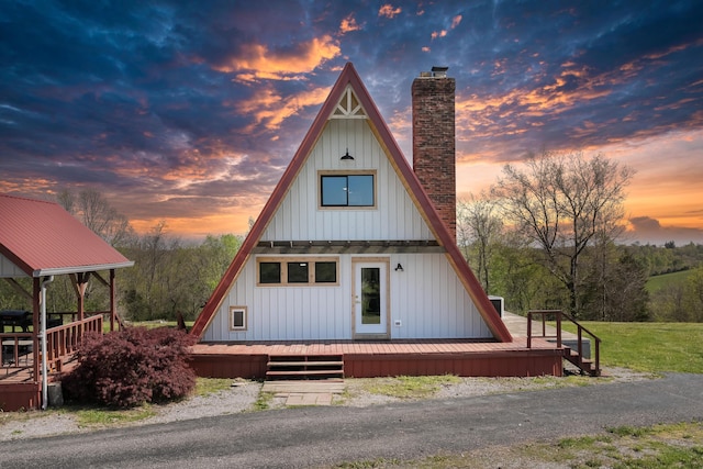a-frame home featuring a chimney, board and batten siding, and a wooden deck