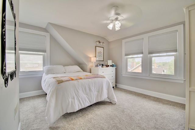 bedroom featuring a ceiling fan, baseboards, light carpet, and lofted ceiling