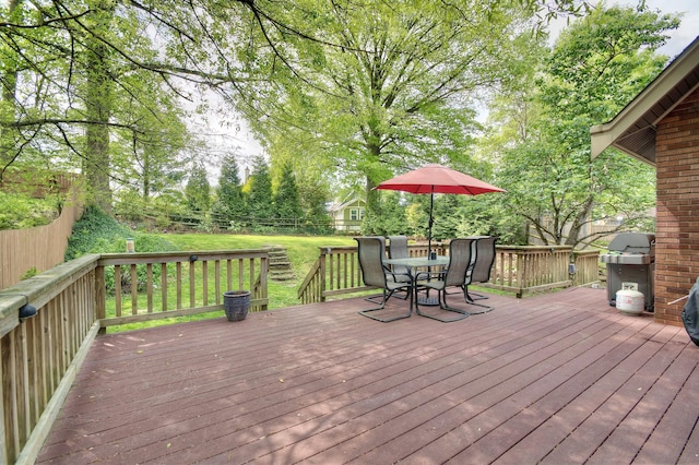 deck featuring outdoor dining area, a fenced backyard, and a lawn