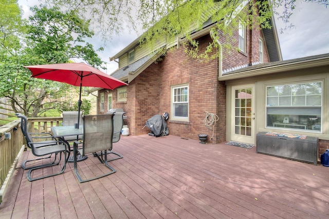 wooden deck with outdoor dining space and grilling area