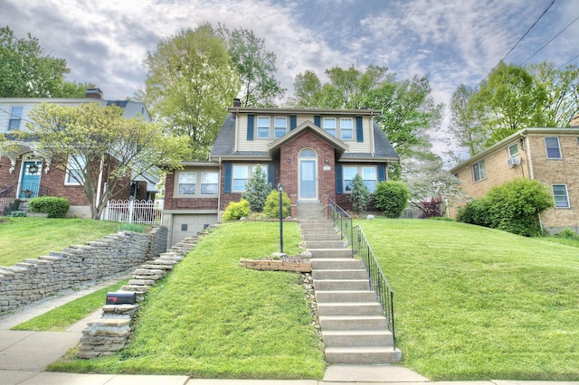 view of front of house with brick siding, a front lawn, stairs, and a garage