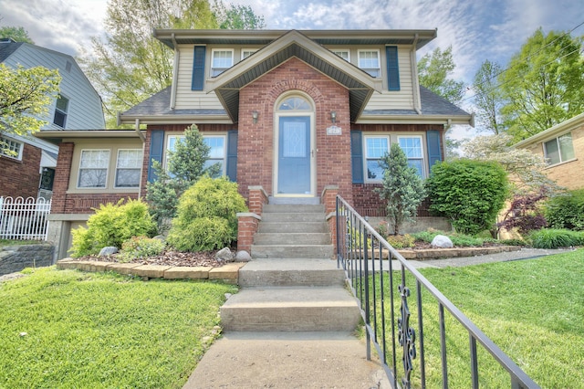 view of front of home with brick siding, fence, roof with shingles, and a front lawn
