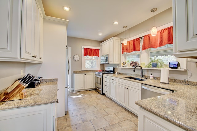 kitchen featuring pendant lighting, a sink, white cabinets, stainless steel appliances, and recessed lighting