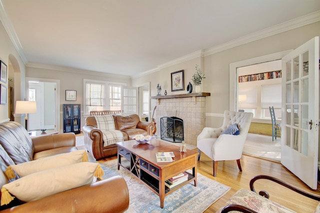 living room featuring crown molding, light wood finished floors, and a fireplace